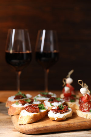 Different delicious bruschettas and red wine on wooden tableの写真素材