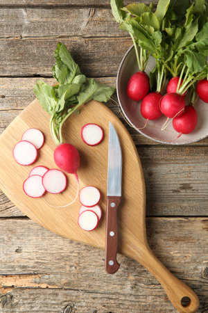 Fresh ripe radishes and knife on wooden table, flat layの写真素材