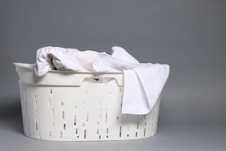 Plastic basket with laundry on gray backgroundの写真素材