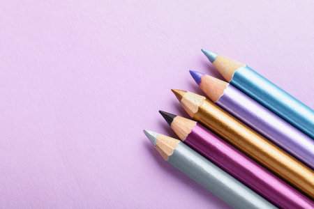 Pencils on lilac background, flat lay. Space for textの写真素材