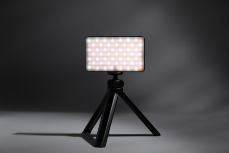 Stylish LED lamp on tripod against gray backgroundの写真素材