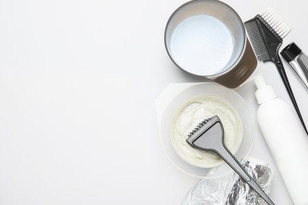 Professional tools and products for hair dyeing on light background, flat lay. Space for textの写真素材