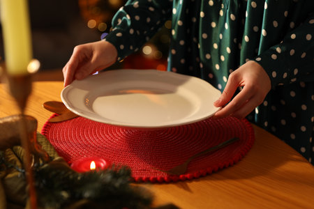 Woman setting table for Christmas dinner indoors, closeupの写真素材
