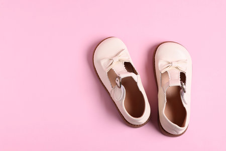 Pair of stylish kid's shoes on pink background, flat lay. Space for textの写真素材