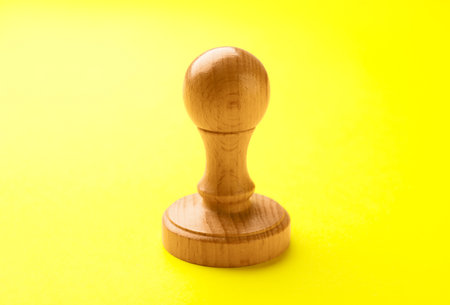 One wooden stamp on yellow background, closeupの写真素材