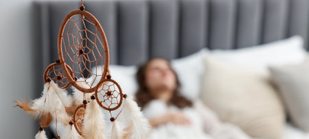 Beautiful dream catcher and woman sleeping on bed at home, selective focusの写真素材