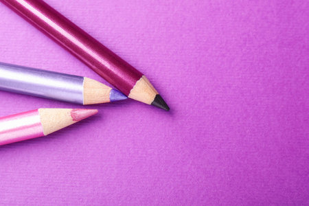 Pencils on purple background, flat lay. Space for textの写真素材