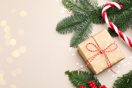 Fir tree branches, gift and Christmas decor on light background, flat lay with bokeh effect. Space for textの写真素材