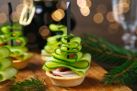 Christmas trees made with cucumber, ham and festive decor on table, closeupの写真素材