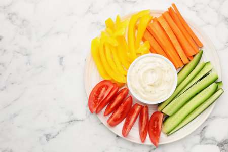 Different fresh vegetables and sauce on white marble table, top view. Space for text