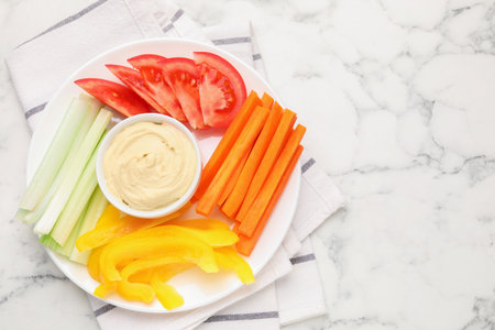 Different fresh vegetables and sauce on white marble table, top view. Space for text