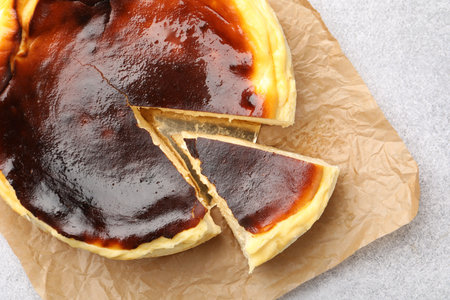 Cut Basque cheesecake on light gray textured table, top viewの写真素材