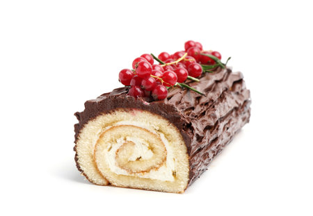 Delicious Yule log (traditional Christmas cake) with redcurrant isolated on whiteの写真素材