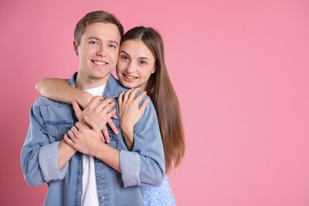 Lovely couple hugging on pink background, space for text. Romantic dateの写真素材