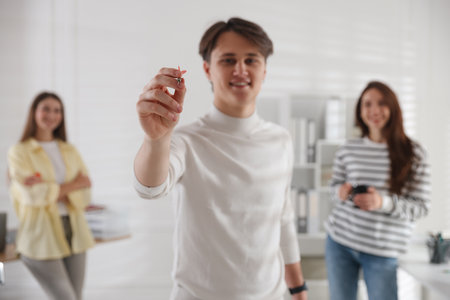 Man playing darts with colleagues in office, selective focusの写真素材