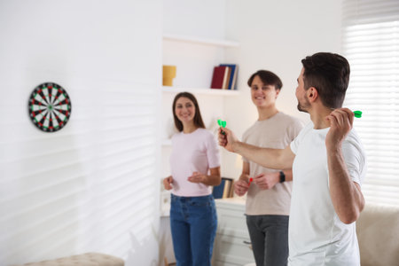 Man and his friends playing darts at home, selective focusの写真素材