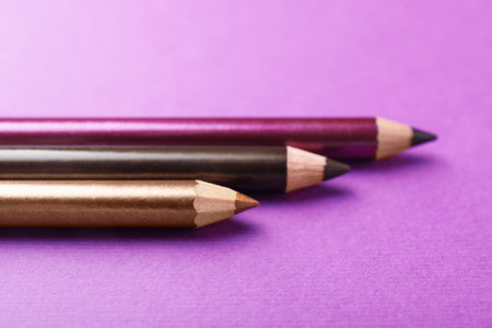 Different eye pencils on purple background, closeupの写真素材