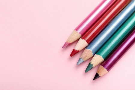 Bright pencils on pink background, flat lay. Space for textの写真素材