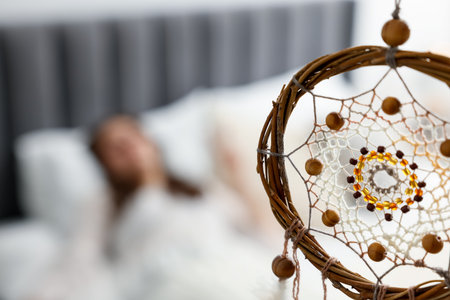Beautiful dream catcher and woman sleeping on bed at home, selective focusの写真素材