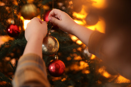 Little boy decorating Christmas tree at home, closeupの写真素材