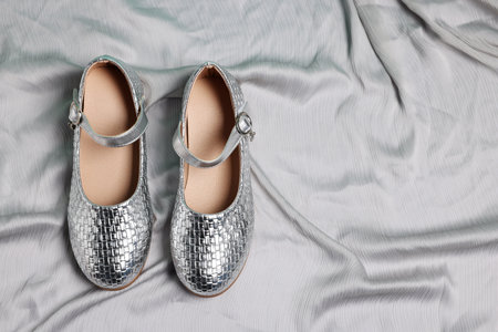 Pair of stylish kid's shoes on gray fabric, flat lay. Space for textの写真素材
