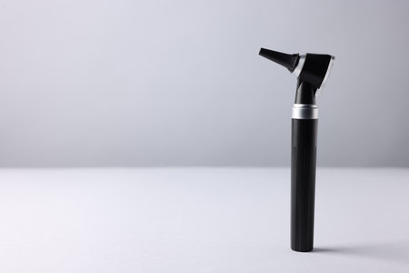 Hearing test. Modern otoscope on light gray background, closeup. Space for textの写真素材