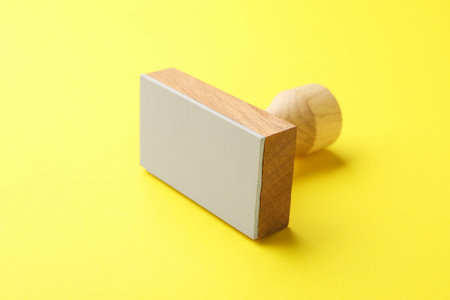 One wooden stamp on yellow background, closeupの写真素材