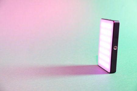 Modern glowing LED lamp on color background. Space for textの写真素材