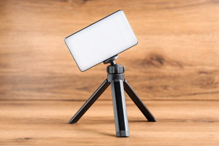 LED lamp on tripod against wooden backgroundの写真素材
