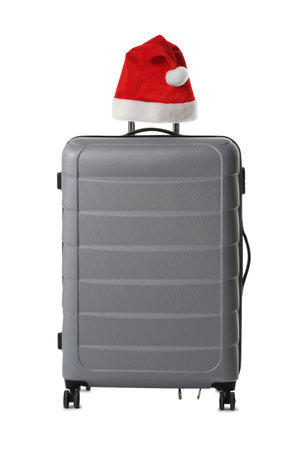 Stylish gray suitcase with Santa hat isolated on white. Christmas vacationの写真素材