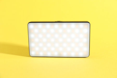 One stylish LED lamp on yellow backgroundの写真素材