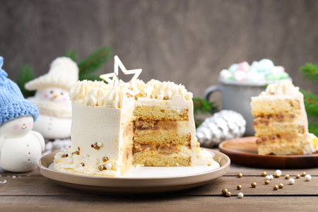 Delicious cake with Christmas decor and marshmallows on wooden table, closeup