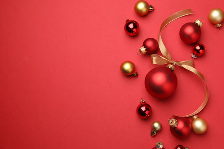 Beautiful Christmas tree ornaments on red background, flat lay. Space for textの写真素材