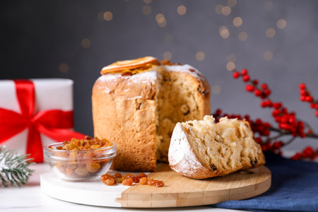 Christmas food. Delicious Panettone cake and festive decor on white table against background with...