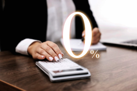 Woman with paperwork using calculator at table, closeup. 0 percent representing zero commissionの写真素材