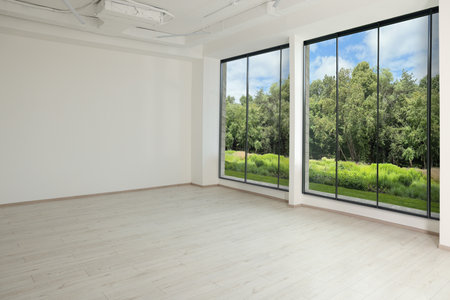 Large windows with garden view in empty room.