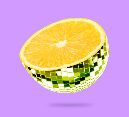 Disco ball with orange inside in air on violet backgroundの写真素材
