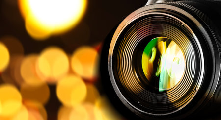 Camera lens against blurred lights, bokeh effect. Banner design