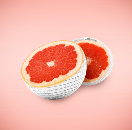 Disco ball with grapefruit inside. Halves on pink gradient backgroundの写真素材