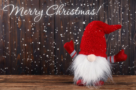 Merry Christmas! Holiday card with cute gnome on wooden tableの写真素材