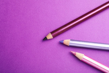 Pencils on purple background, flat lay. Space for textの写真素材