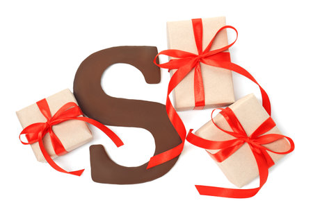 Saint Nicholas (Sinterklaas) day. Chocolate letter S and gift boxes isolated on white, top viewの写真素材