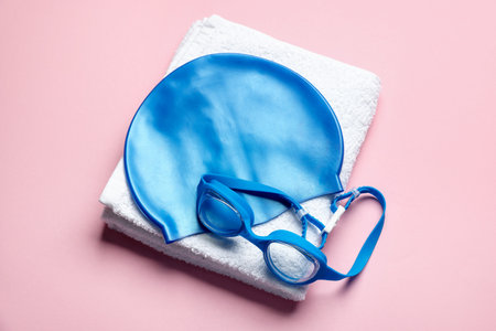 Swim cap, towel and goggles on pink background, flat layの写真素材