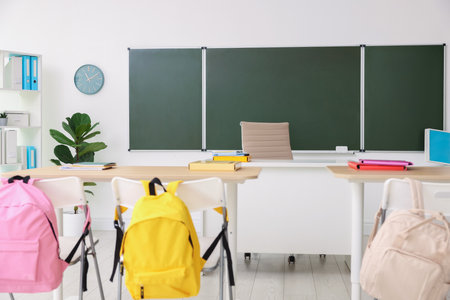 Green chalkboard and stylish furniture in classroom. Mockup for designの写真素材
