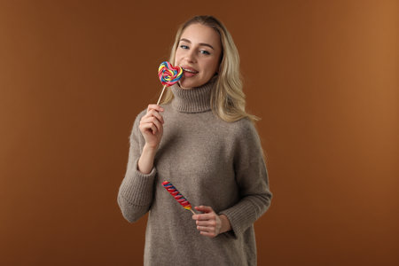 Woman with lollipops on brown background