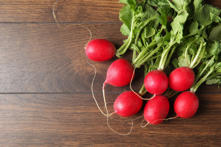Fresh ripe radishes on wooden table, top view. Space for textの写真素材