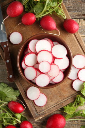 Fresh ripe radishes and knife on wooden table, flat layの写真素材