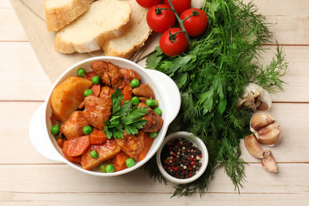 Delicious cooked stew served on light wooden table, flat layの写真素材