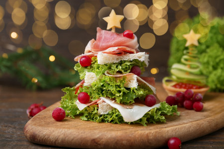 Christmas tree shaped snack made with lettuce, ham, croutons and berries on wooden table, closeupの写真素材