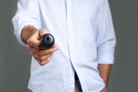 Man with hidden spy camera on gray background, closeupの写真素材